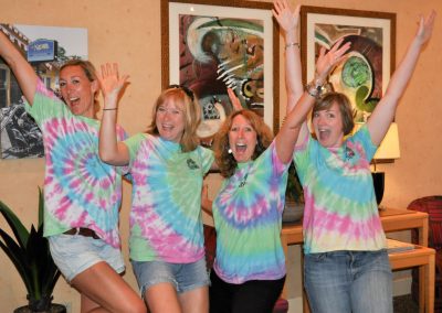 Four ladies wearing tie-died tshirts and cheering