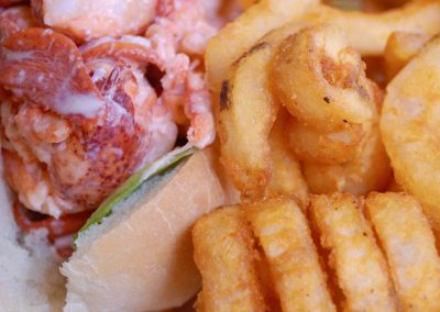 close up of lobster roll and curly fries.