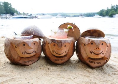Carved coconuts holding mixed drinks.