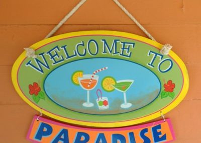 Wooden sign. Text: Welcome to Paradise